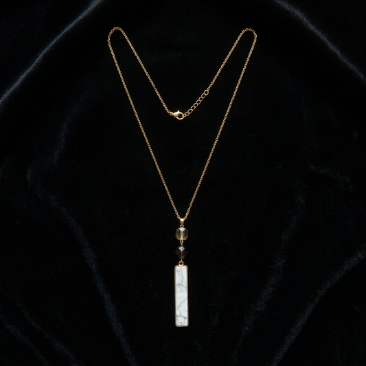 Gold necklace with a pendant on a black velvet background