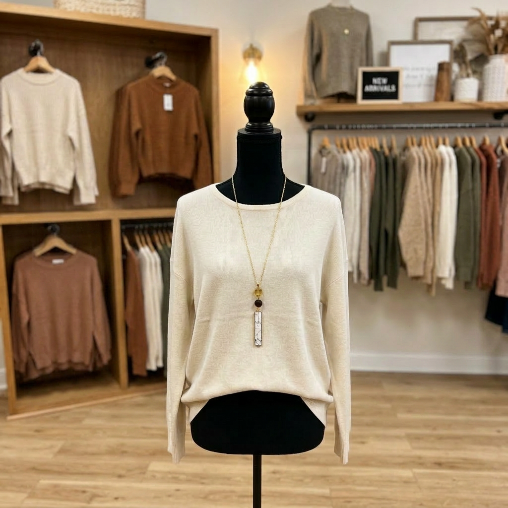 Mannequin wearing a beige sweater with a store interior in the background