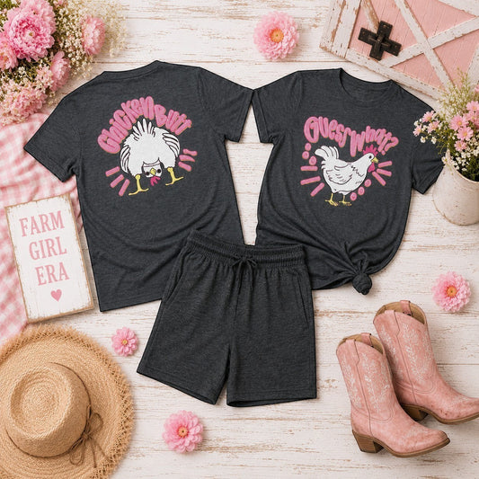 Tea Shirt Shoppe Wholesale dark heather grey 100% cotton graphic tees with chicken designs and pink text. One says "Chicken Butt" and the other says "Guess What?"