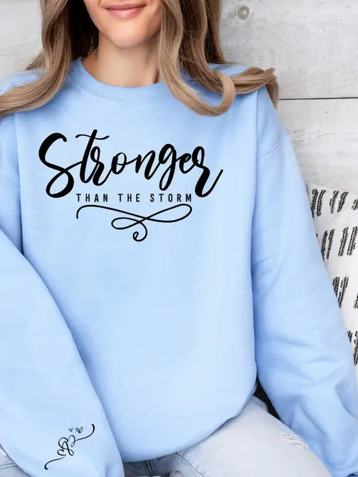 Stronger Than The Storm Graphic Sweatshirt Sweatshirt Tea Shirt Shoppe Small Lt. Blue