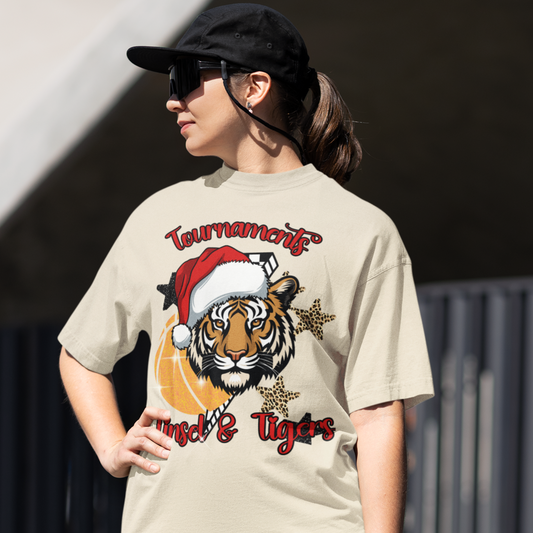 Person wearing a beige t-shirt with a tiger graphic and text, standing outdoors.
