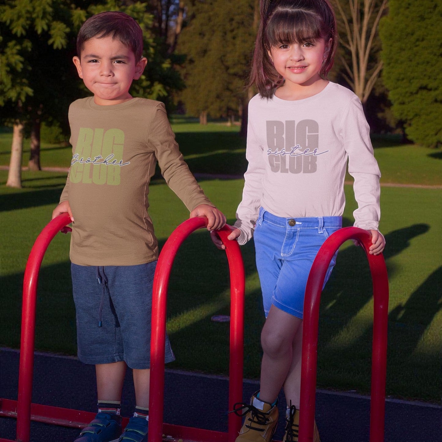 Two children standing on a playground structure with 'BIG' text on their shirts.