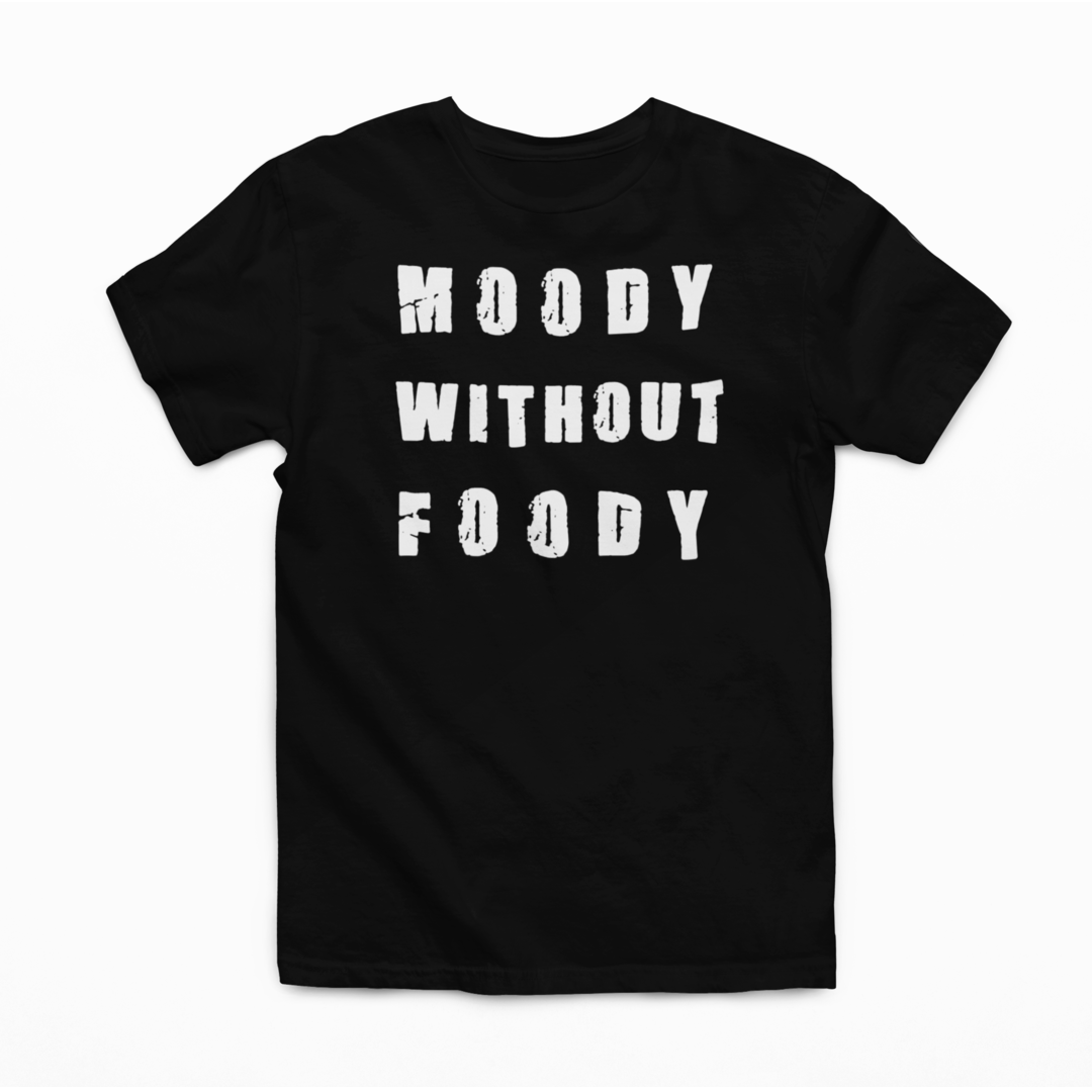 "A black t-shirt laid out on a white background, featuring the phrase 'MOODY WITHOUT FOODY' in large, white, distressed font. The shirt is unadorned otherwise, with a crew neckline and short sleeves, emphasizing the message as the focal point."