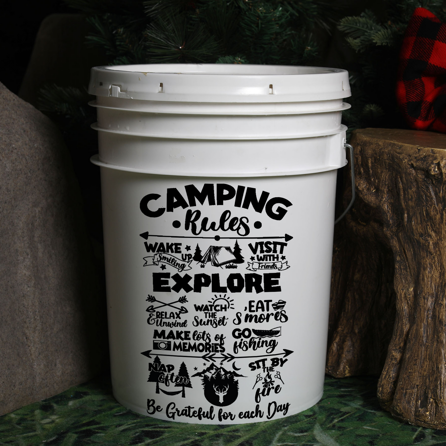 White bucket with 'Camping Rules' text and graphics on a natural background