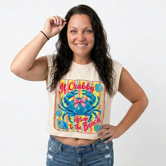 Woman wearing a sleeveless graphic top and denim shorts on a white background