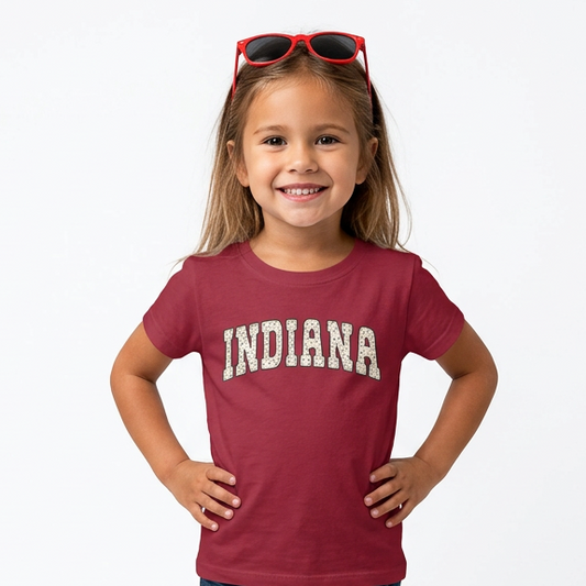 Young girl wearing a red 'Indiana' t-shirt on a white background