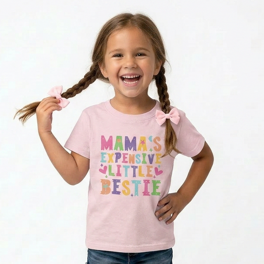 Young girl wearing a pink t-shirt with colorful text, standing against a white background