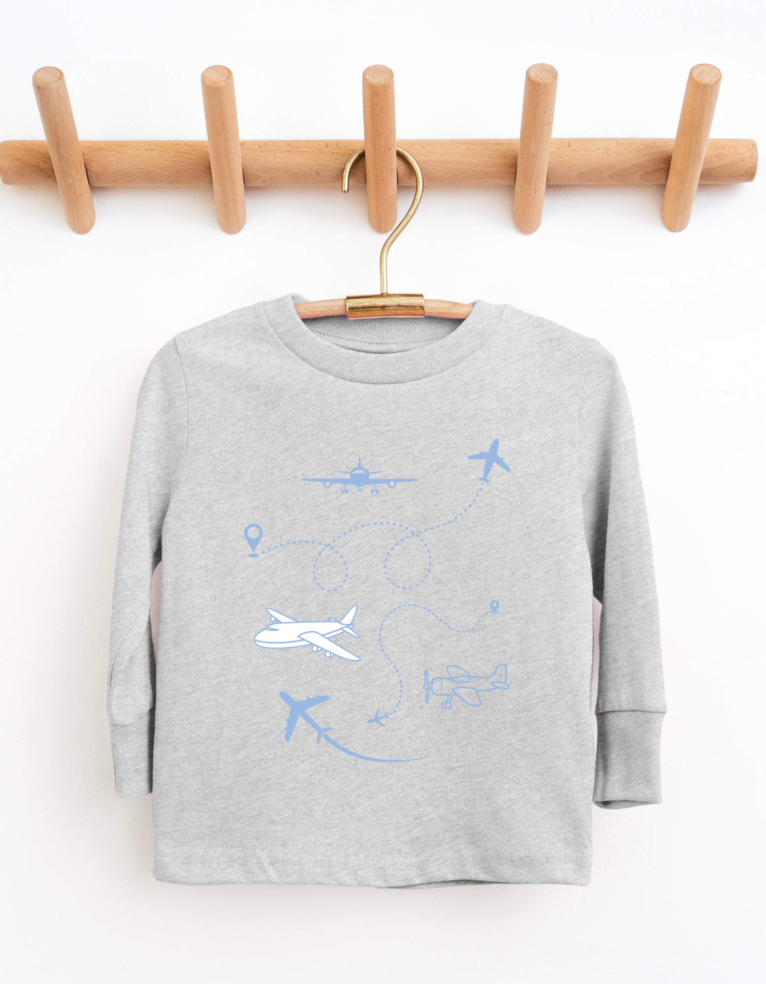 Gray sweatshirt with blue airplane and balloon designs on a wooden hanger against a white background