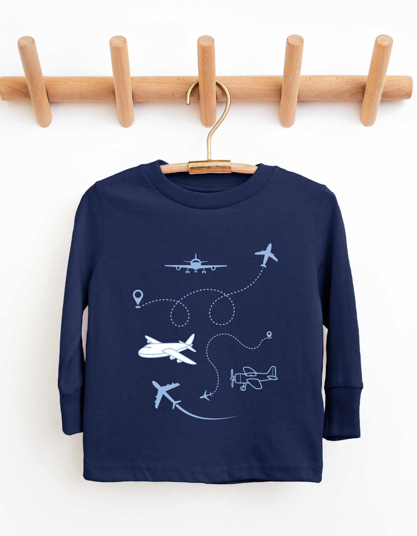 Navy blue children's sweatshirt with airplane designs on a wooden hanger against a white background