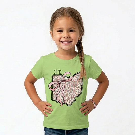 Young girl wearing a green t-shirt with a  Ohio design on a white background