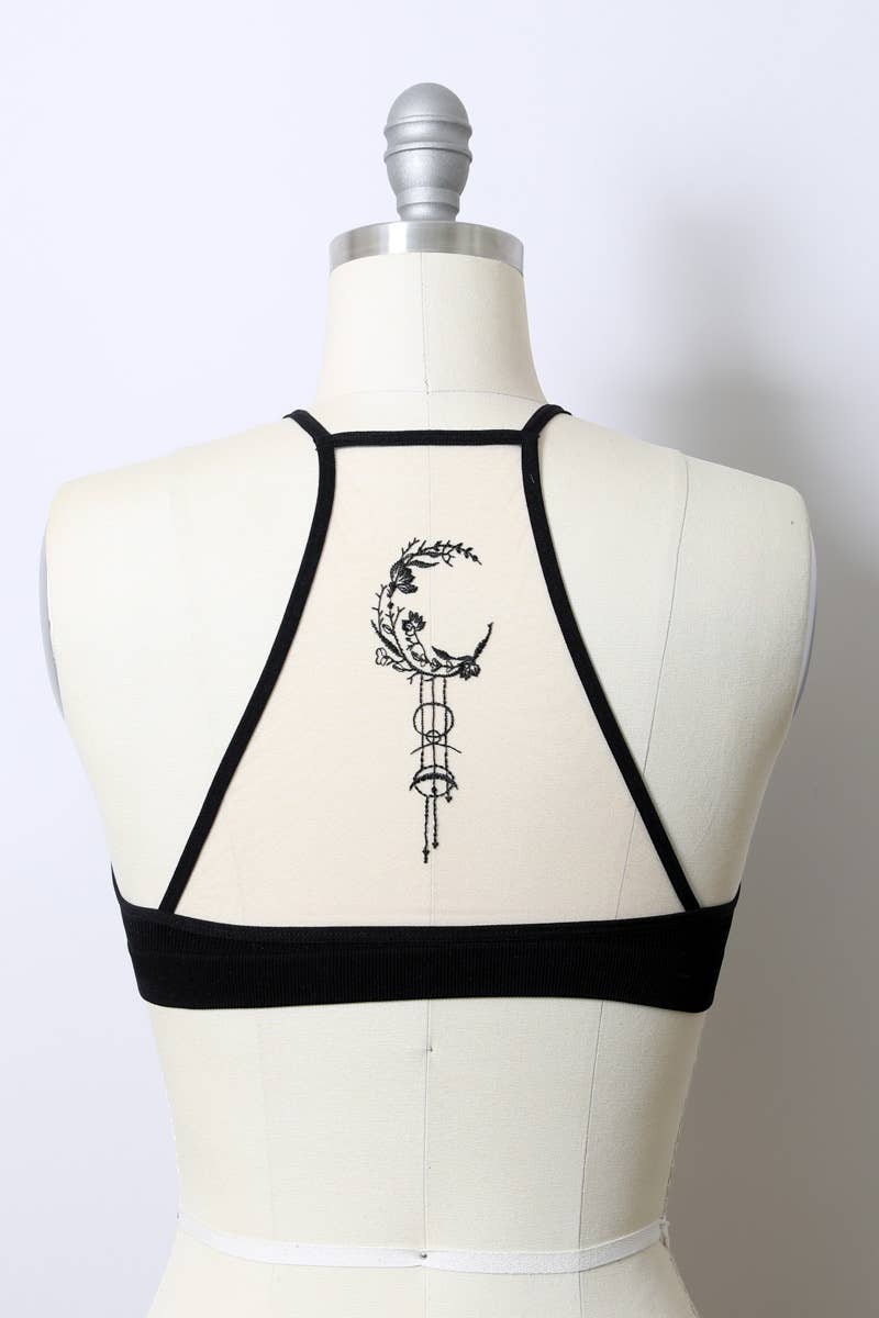 Black strappy top on a mannequin with a white background