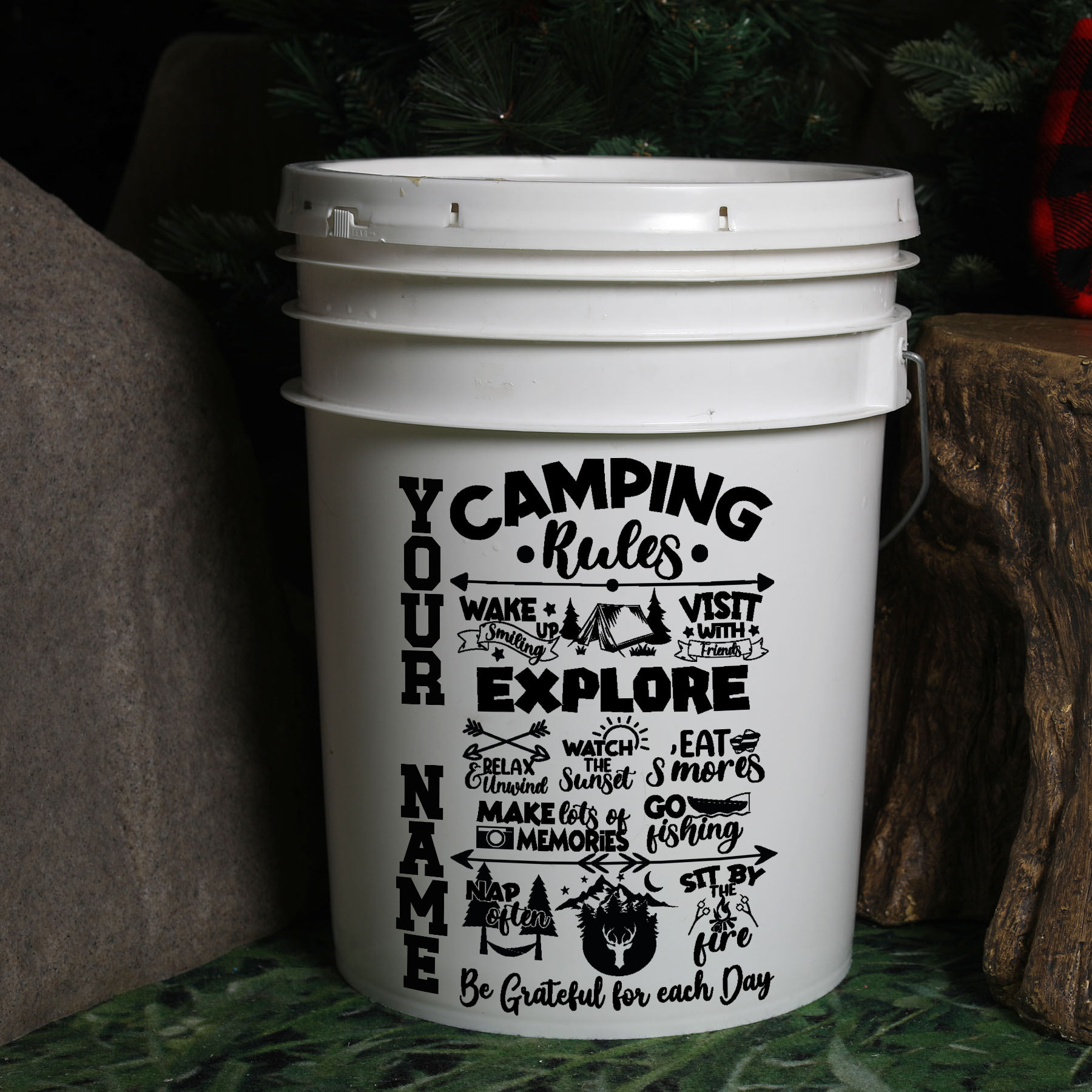 White bucket with camping-themed text and design on a natural background