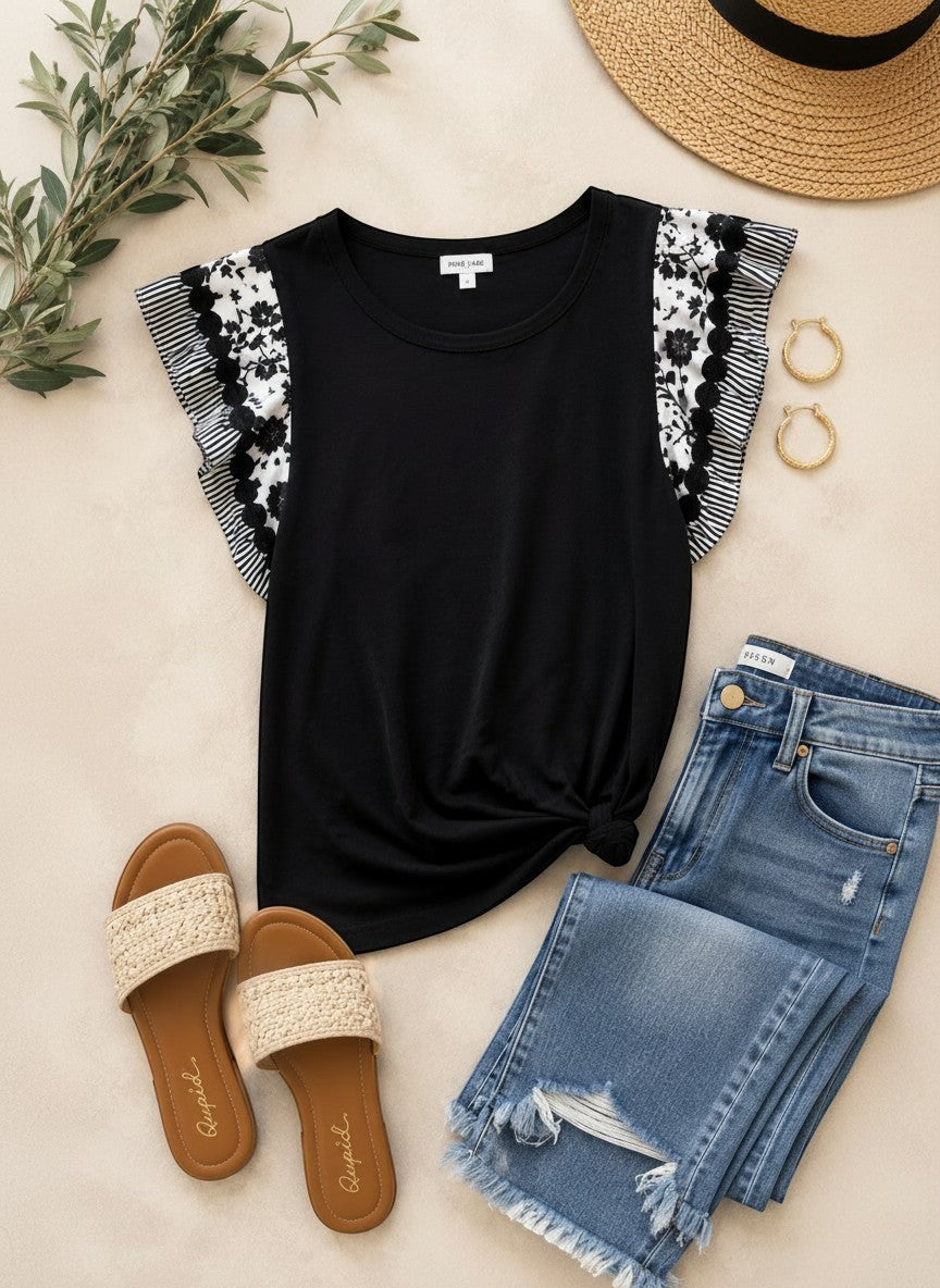 Tea-Shirt Shoppe black ribbed top with floral flutter sleeves, styled with denim jeans, straw hat, and sandals.