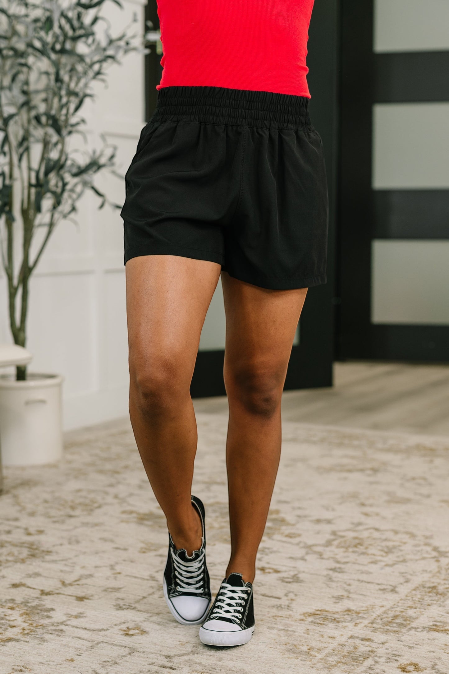 Tea-Shirt Shoppe black high-waisted athletic shorts with a wide-leg fit, elastic waistband, and side pockets.
