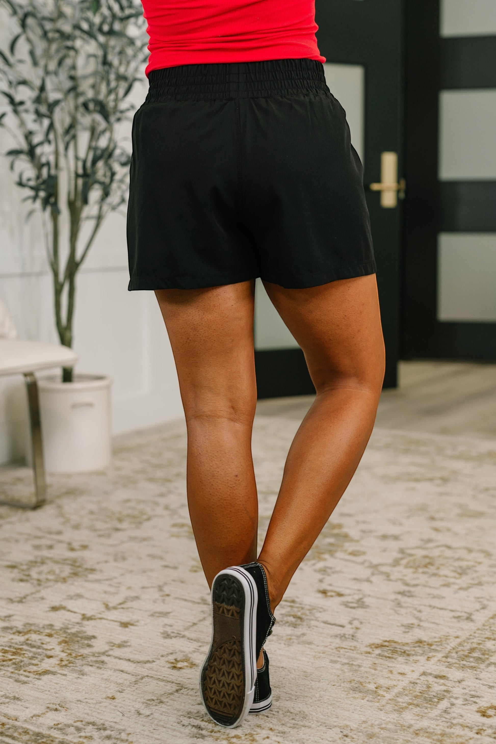 Tea-Shirt Shoppe black high waisted athletic shorts with a wide leg fit and elastic waistband, back view