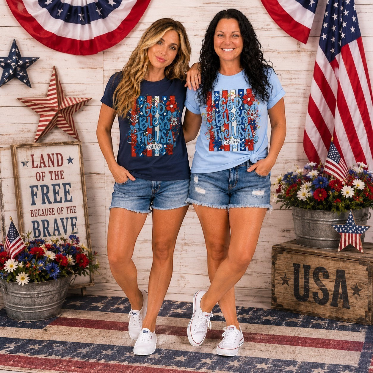 Tea-Shirt Shoppe light blue graphic tee with "God Bless The USA" text and floral design, Est. 1776 detail.
