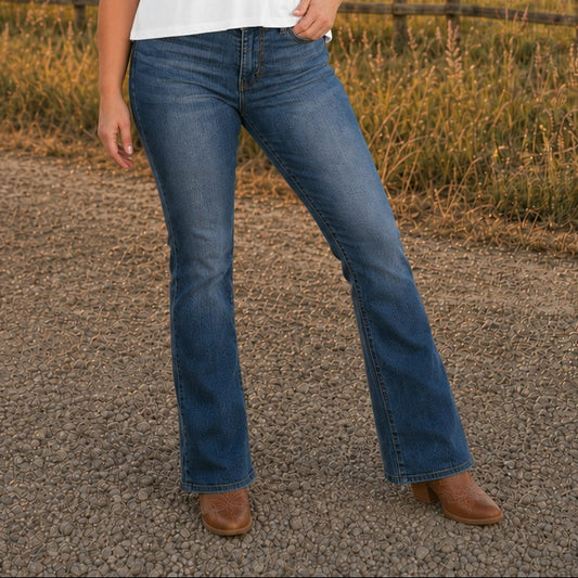 Tea-Shirt Shoppe Judy Blue dark wash high-waist bootcut jeans with tummy control, worn with brown western boots.