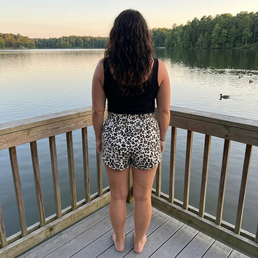 Tea-Shirt Shoppe leopard print athletic shorts with smocked high-rise waistband and curved hem.