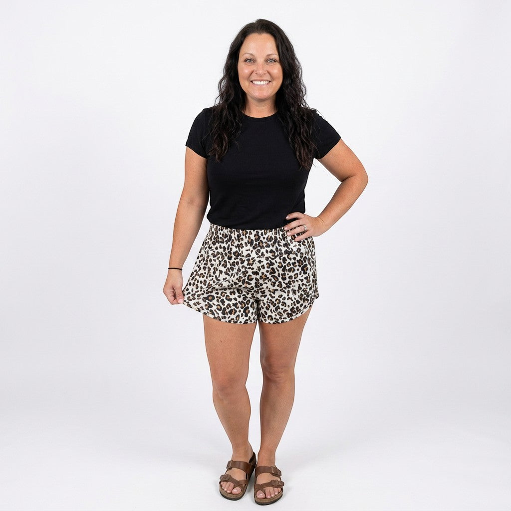 Tea-Shirt Shoppe leopard print athletic shorts with a high-rise smocked waistband and curved hem.