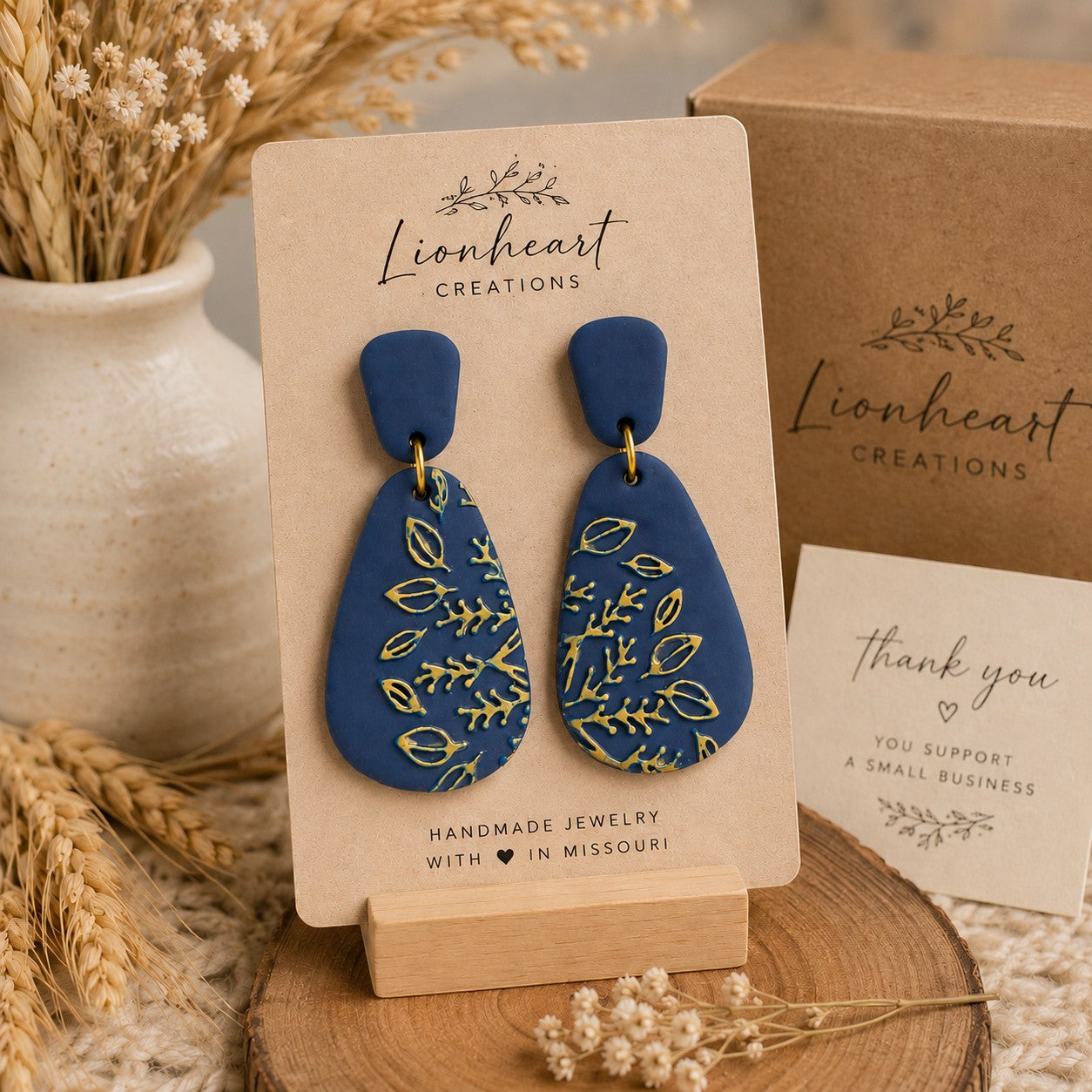 Tea-Shirt Shoppe Midnight Meadow teardrop earrings in matte navy blue polymer clay with gold botanical patterns.