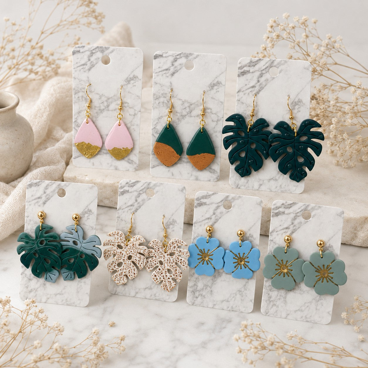 Tea-Shirt Shoppe Palm & Petal Collection polymer clay earrings featuring floral and leaf designs in assorted colors.