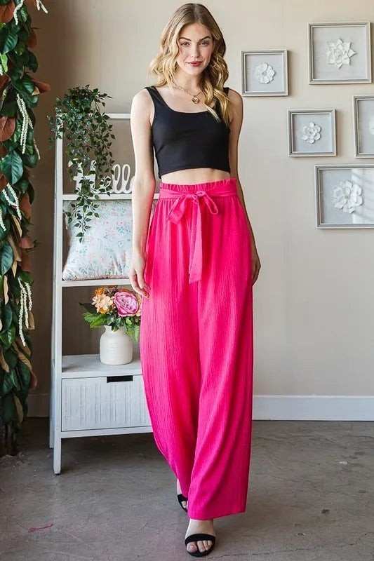 Tea-Shirt Shoppe hot pink wide-leg pants with paperbag waist, tie front, and side pockets. Polyester-spandex blend.