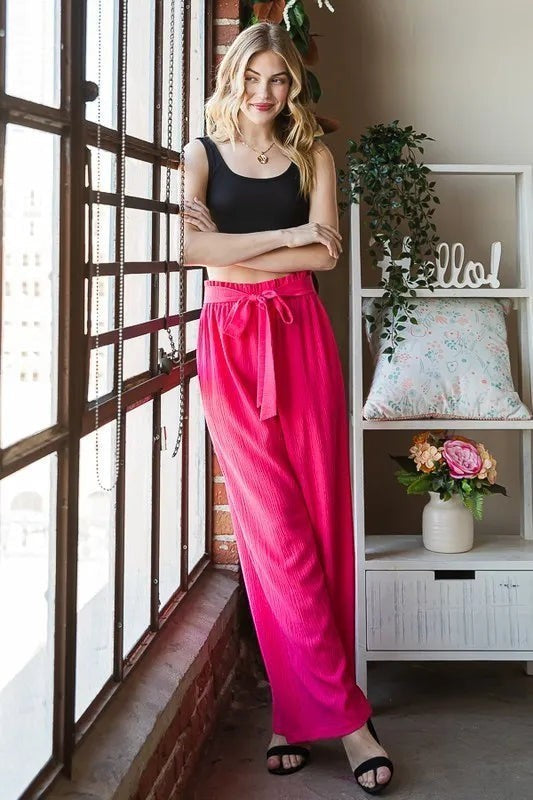Tea-Shirt Shoppe hot pink polyester spandex paperbag waist pants with self-tie detail and side pockets.