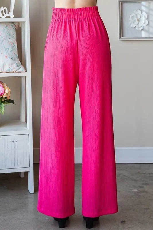 Tea-Shirt Shoppe hot pink wide leg pants with paperbag waist and side pockets, made of polyester and spandex blend.