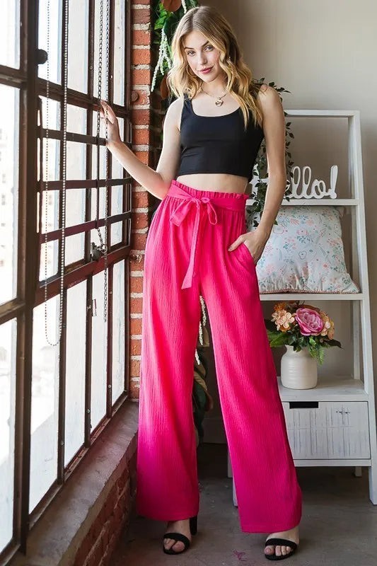 Tea-Shirt Shoppe hot pink wide-leg pants with paperbag waist, self-tie belt, and side pockets. Polyester-spandex blend.