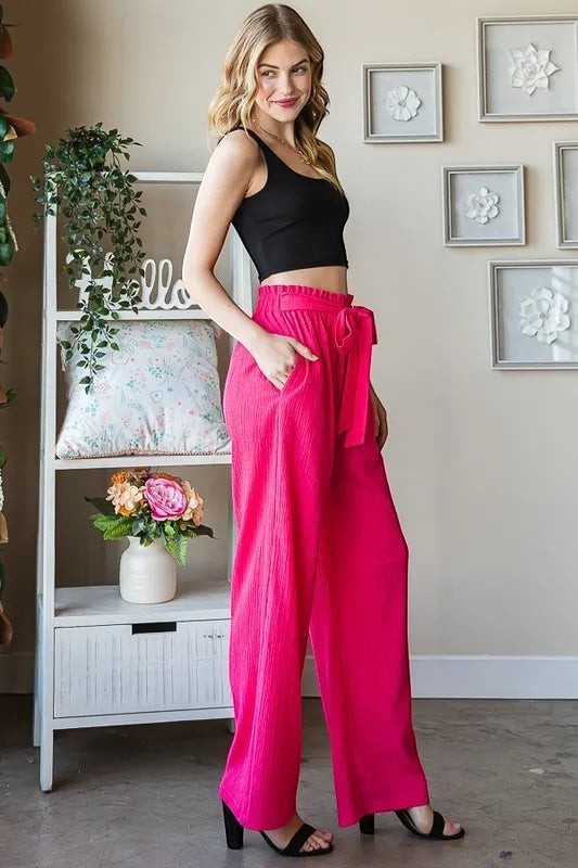 Tea-Shirt Shoppe bright pink polyester-spandex pants with paperbag waist, tie belt, and side pockets. Plus size.