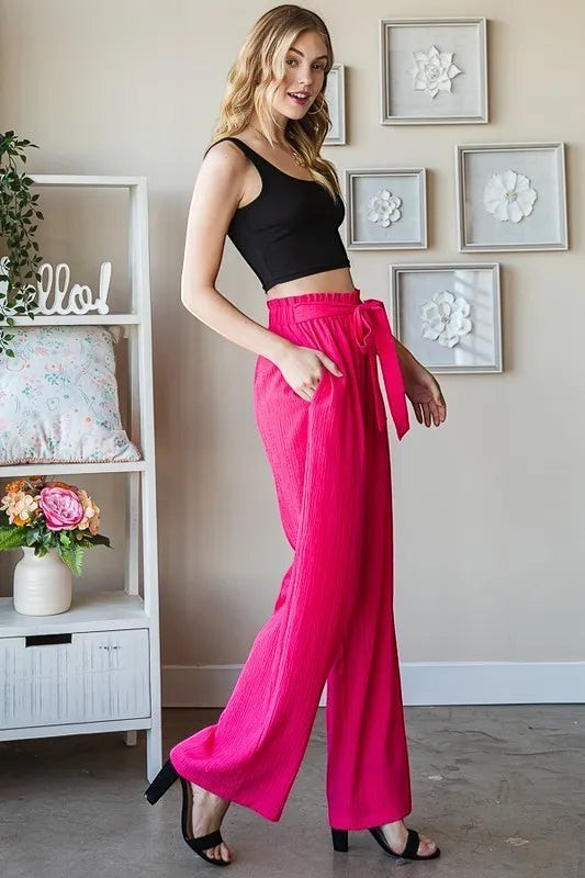 Tea-Shirt Shoppe plus size hot pink wide-leg pants with paperbag waist, self-tie belt, and side pockets. Polyester-spandex blend.