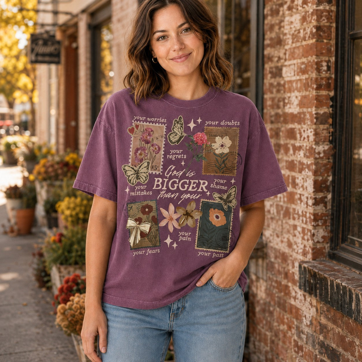 Tea-Shirt Shoppe vintage-style purple cotton graphic tee with floral and butterfly illustrations on a smiling woman.