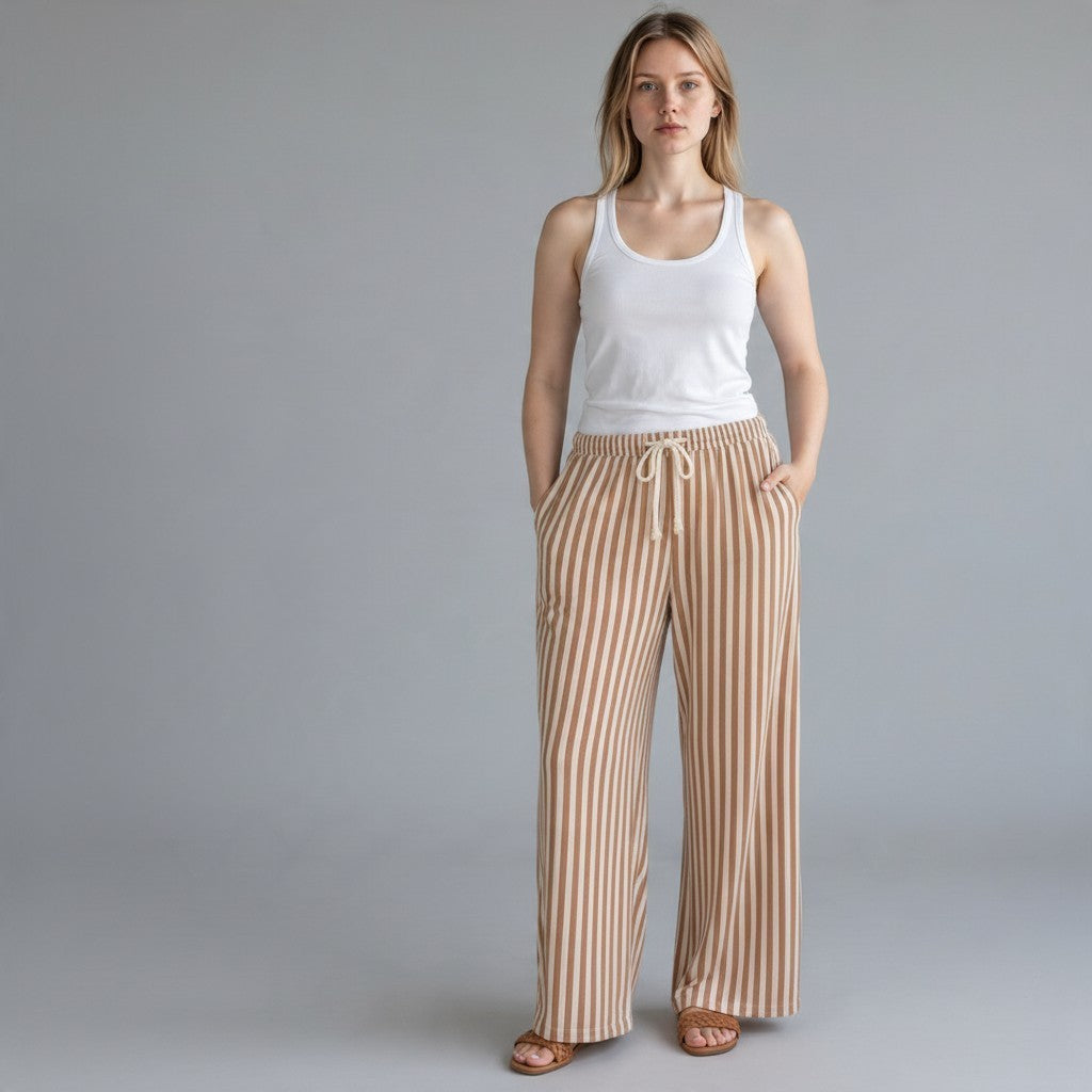 A model wearing Tea-Shirt Shoppe striped oversized wide leg pants with an elastic drawstring waist and side pockets.