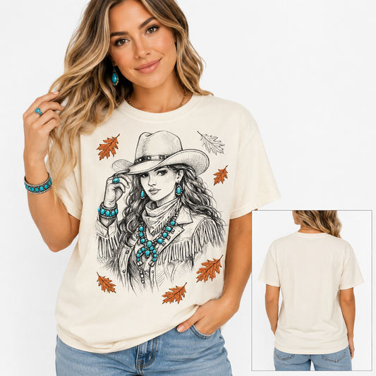 Tea Shirt Shoppe Wholesale cream Gildan graphic tee featuring a cowgirl illustration and autumn leaves on a woman