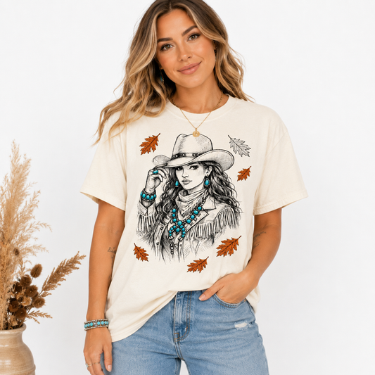 Tea Shirt Shoppe Wholesale cream Gildan graphic tee featuring a cowgirl illustration with autumn leaves