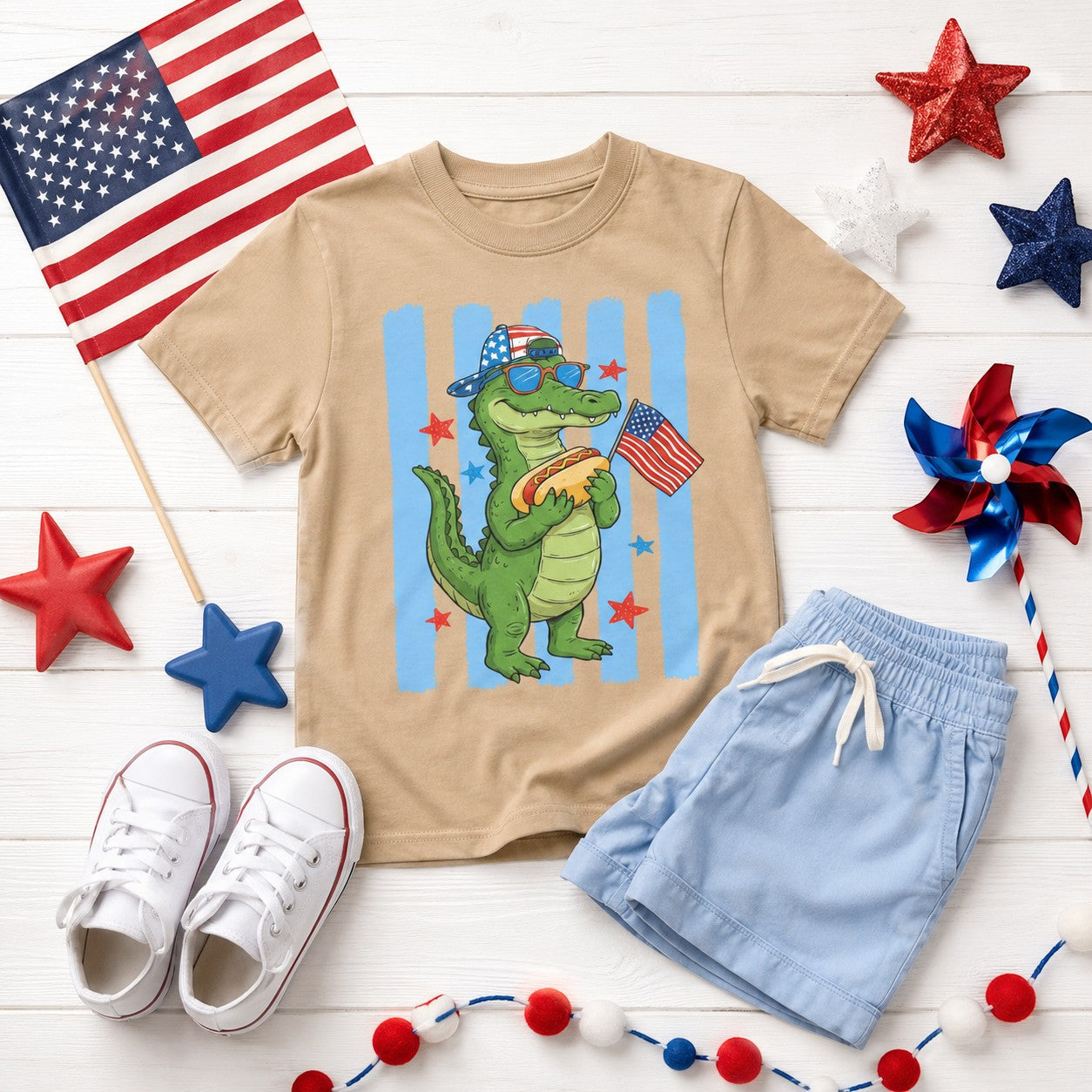 Tea Shirt Shoppe Wholesale tan 100% cotton youth graphic tee with alligator holding hot dog and American flag.