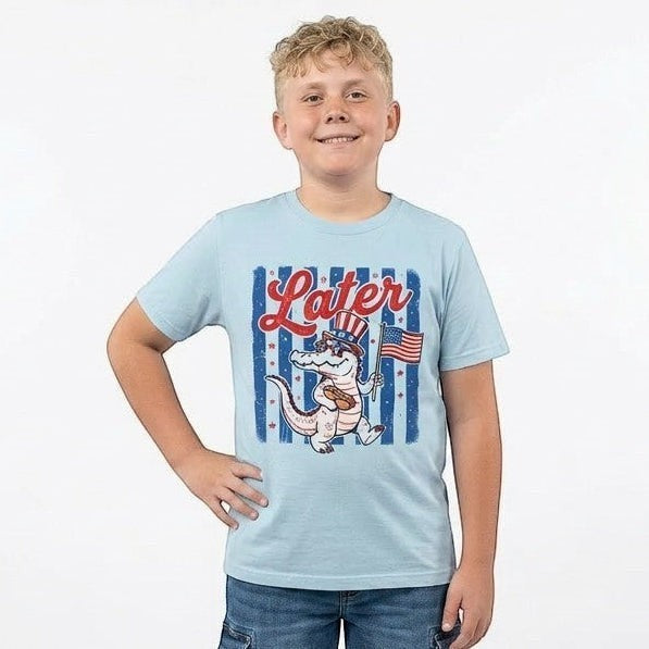 Tea Shirt Shoppe Wholesale light blue youth graphic tee with alligator in Uncle Sam hat holding American flag.