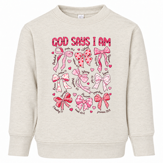 Tea Shirt Shoppe Wholesale toddler sweatshirt in oatmeal featuring pink bow graphics and faith-based affirmations.
