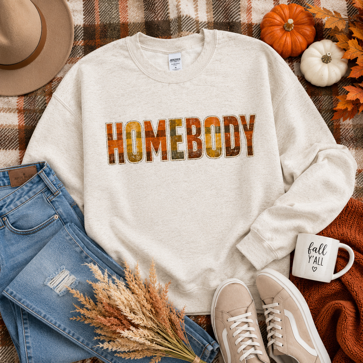 Tea Shirt Shoppe Wholesale oatmeal heather crewneck sweatshirt with rustic plaid HOMEBODY graphic on a fall flat lay