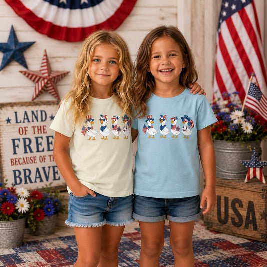 Tea Shirt Shoppe Wholesale youth graphic tee with patriotic ducks in red, white, and blue attire.