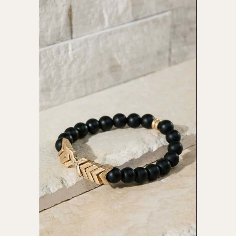 This is a super cute natural black stone stretch bracelet with a metal chevron pendant.