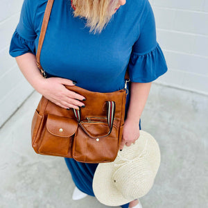 Complete your outfit with this caramel faux leather luxury designer handbag. This messenger-style handbag features multiple pockets, a long shoulder strap, and plenty of room. This handbag is a nice midsize purse. 12.5" x 11.5" x 5".