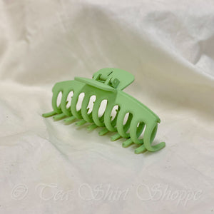 green claw clip on white surface
