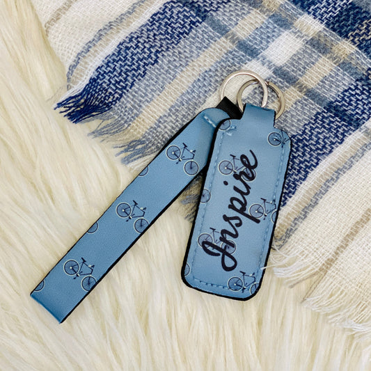 Our Blue Bicycle Lipbalm Holder & Keychain is not just a cute gift for her, it is also practical. It has a lipbalm holder and a keychain so you can attach it to your purse, backpack or keys, and then you never have to worry about misplacing it. On the lipbalm holder it says "Inspire," in a lovely cursive font. The bicycle print lipbalm holder is the perfect stocking stuffer for women of any age.  Bicycle Print Keychain measurements: 5" Lipbalm holder measurements: 3.75"x1.5"