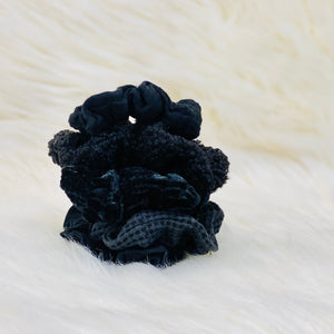 5 black textured scrunchies stacked.