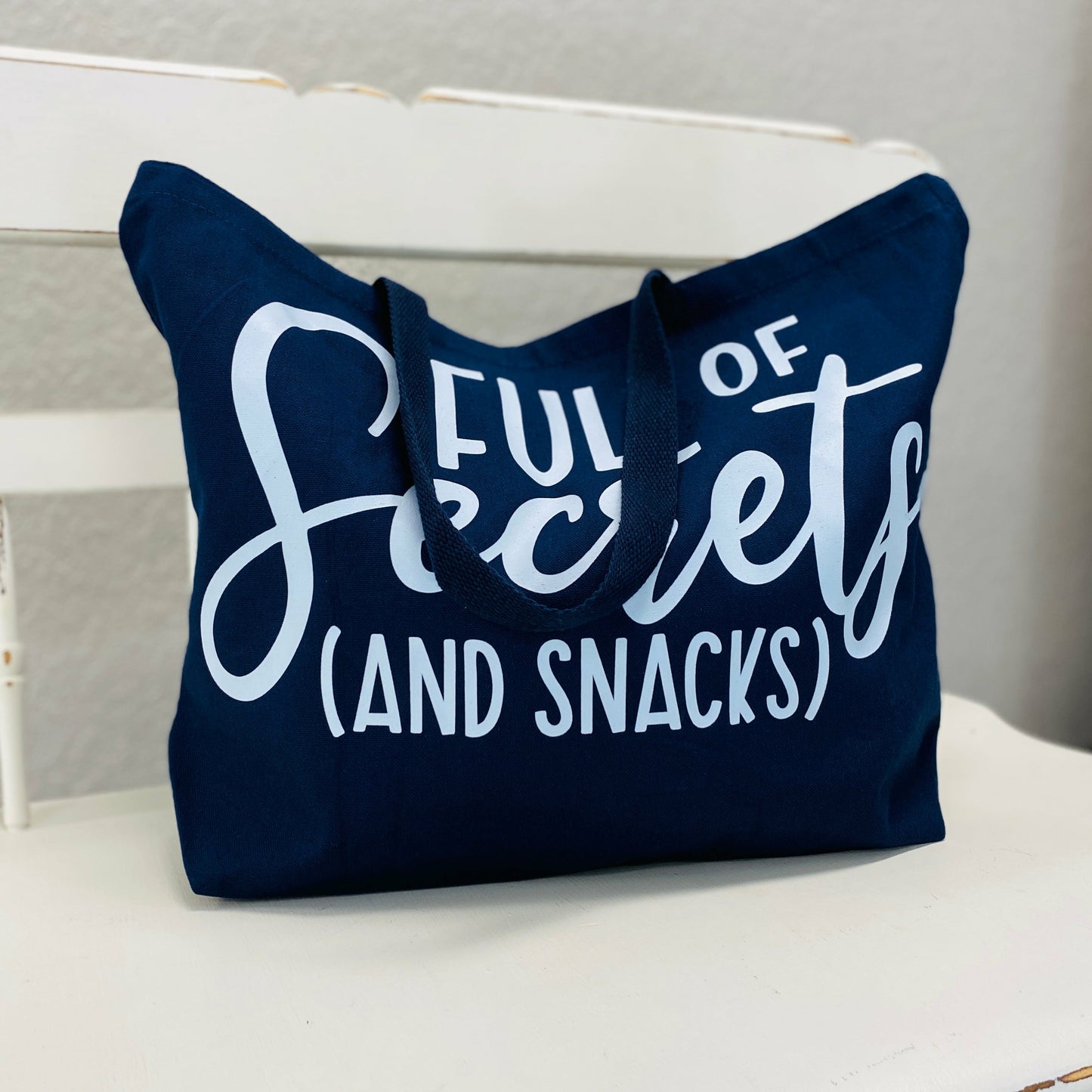 Full Of Secrets Navy Bag  As Damian once said "that's why her hair is so big, it's full of secrets". If you're a mean girls kinda person you HAVE to get this bag. Very spacious so you have plenty of room for snacks and secrets.  %100 cotton  Tea Shirt shoppe 417-262-8828