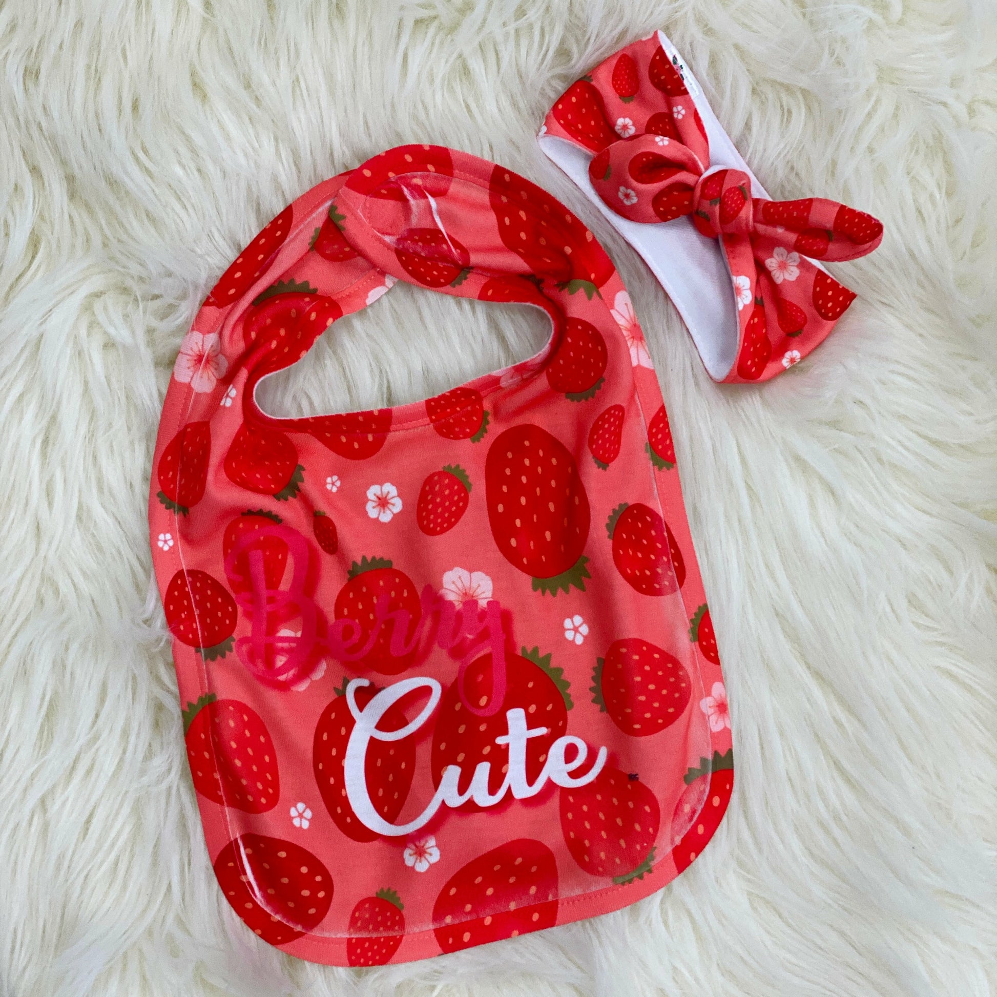 Baby Bib and Headband Set - Strawberry Looking for a special baby gift? Here it is! This adorable bib says "Berry Cute" With red strawberries and a  pink background. It has a velcro attachment in the back. Along with this bib there's an adorable Strawberry head wrap for your little one. Made with a soft polyester materiel. Just wrap around your baby's head and tie in a cute simple knot.   Laughing Giraffe One Size Pink 100% Polyester Strawberry