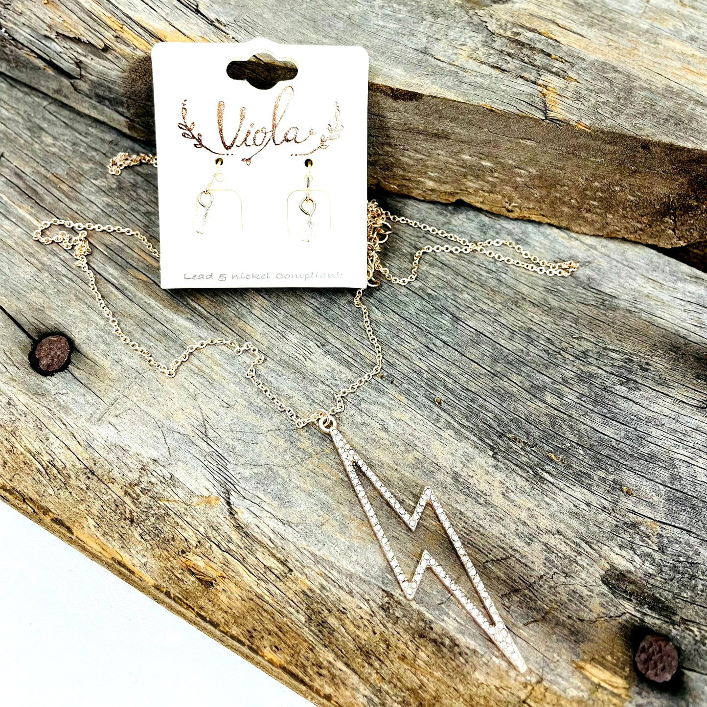 Gold Lightening Bolt Earrings and Necklace on piece of barnwood